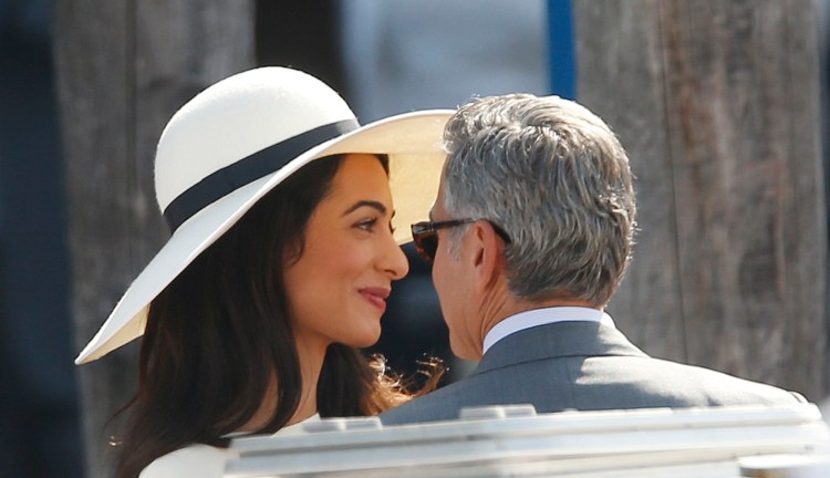 George Clooney and his wife Amal Alamuddin leave the municipal building after their civil marriage ceremony in Venice Monday. The Associated Press