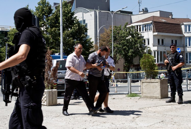Kosovo police escort a Kosovo Albanian man suspected of fighting alongside Islamic radicals in Iraq and Syria to a local court in Pristina Aug. 12, 2014. Kosovo police on arrested at least 40 people in a major operation targeting Islamic radicals suspected of fighting alongside extremists in Iraq and Syria. The Associated Press