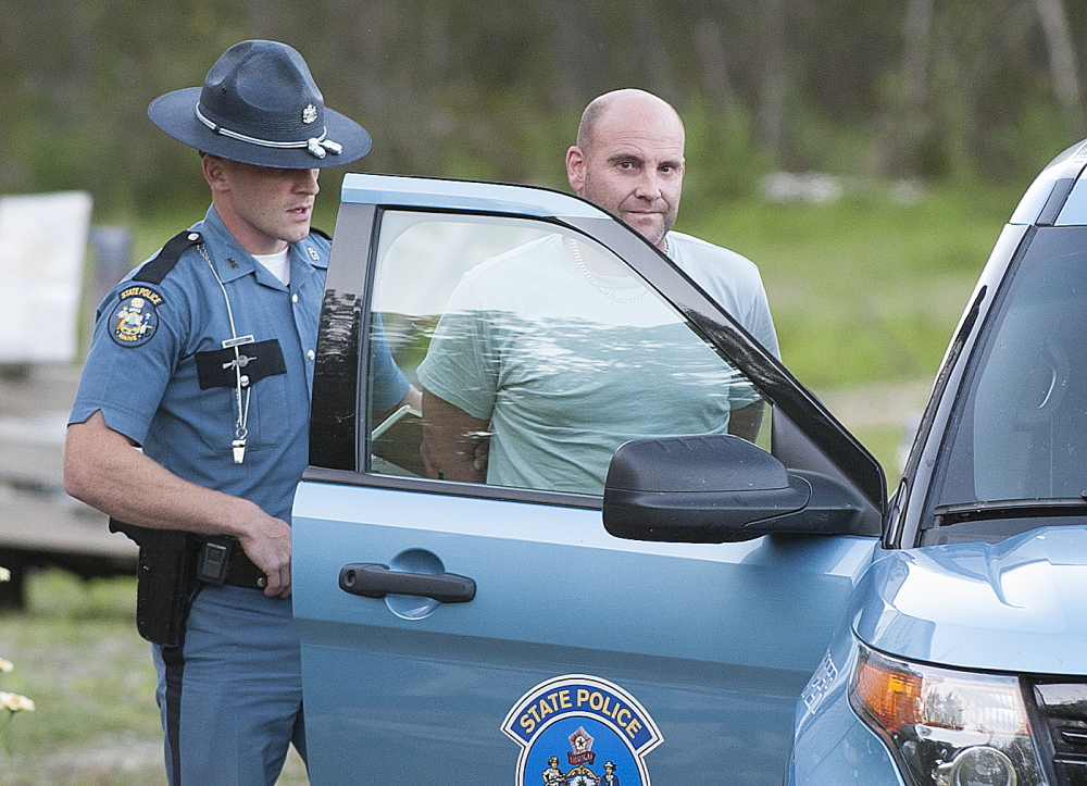 Maine State Police Trooper Scott Duff guides Marc Alberi of Newport to a police cruiser after his arrest Monday. 