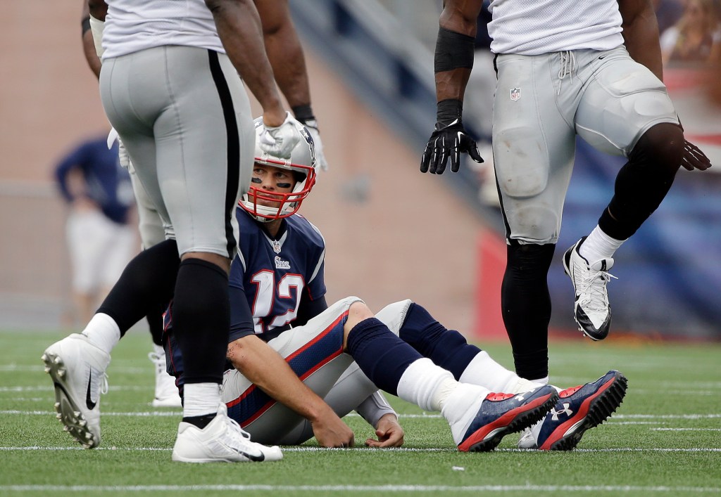 New England Patriots quarterback Tom Brady sits on the turf after being sacked by the Oakland Raiders in the second half of Sunday's game. The Associated Press