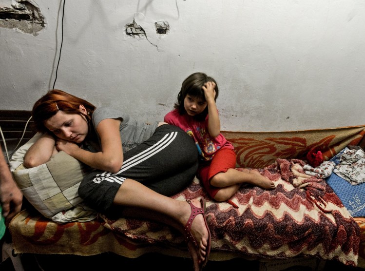 A mother and child lie on the bed in the bomb shelter in Petrovskiy district, in Donetsk, eastern Ukraine, Monday. The district is has suffered the most from the artillery fights between Ukrainian army and Pro-Pussian rebels. The Associated Press