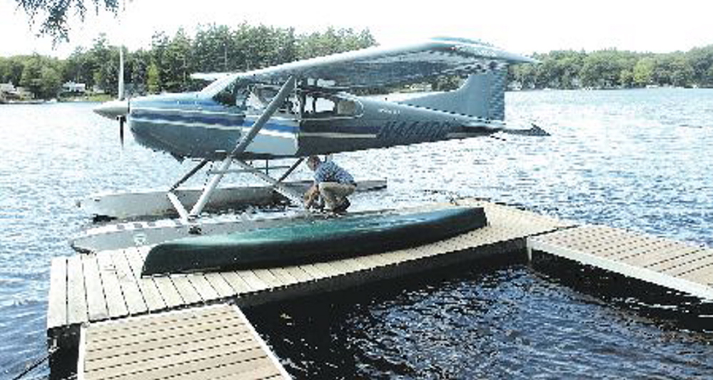 Bill McKay of Oakland secures his float plane to his dock on Messalonskee Lake in August 2006 after taking a short flight.