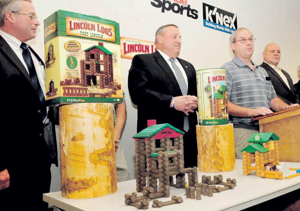 Gov. Paul LePage, center, listens Wednesday as Randy Dickers of Pride Manufacturing announces that the Burnham plant will now mill pieces for Lincoln Log toys. At left is Walt Whitcomb, commissioner of agriculture and at far right is Larry Fanelle of the K’NEX company. 