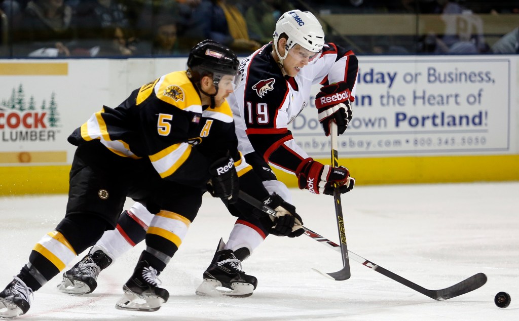 Chris Casto of the Providence Bruins, left, and Henrik Samuelsson of the Portland Pirates compete for control of the puck during the second period. The game drew 5,601 fans after the Pirates struggled through a poor season on and off the ice in Lewiston.
