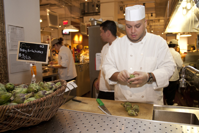At Eataly locations worldwide, a vegetable butcher handles produce for an in-house restaurant and also prepares fresh produce for shoppers to cook at home.