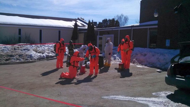 Drug agents wear protective suits as they search for methamphetamine Friday, March 7, 2014 outside the Waterville Fireside Inn & Suites on Main Street in Waterville. 
Contributed photo
