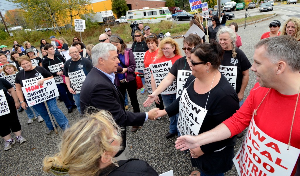 U.S. Rep. Mike Michaud, D-Portland, greets FairPoint workers as they walk a picket line in front of the company at 5 Davis Farm Road in Portland on Friday.