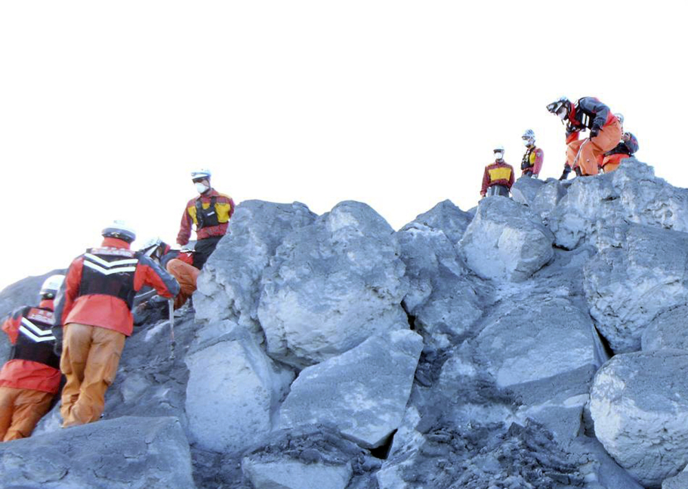 Nagoya City firefighters search for hikers Sunday near the summit of Mount Ontake in Japan. 