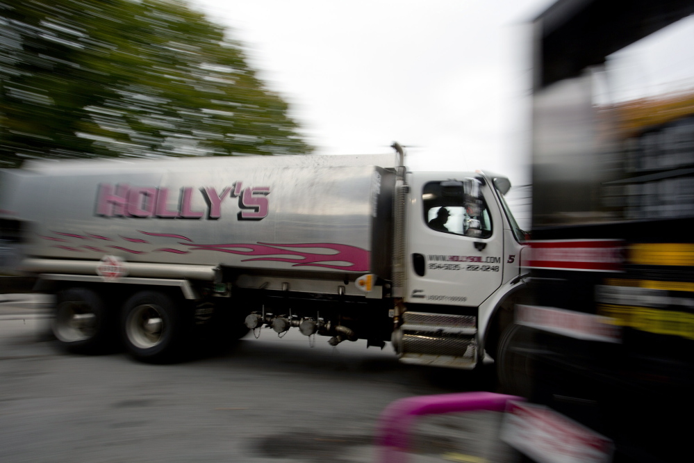 An oil delivery truck moves past a gas pump at Holly’s Super Gas on Main Street in Westbrook. 