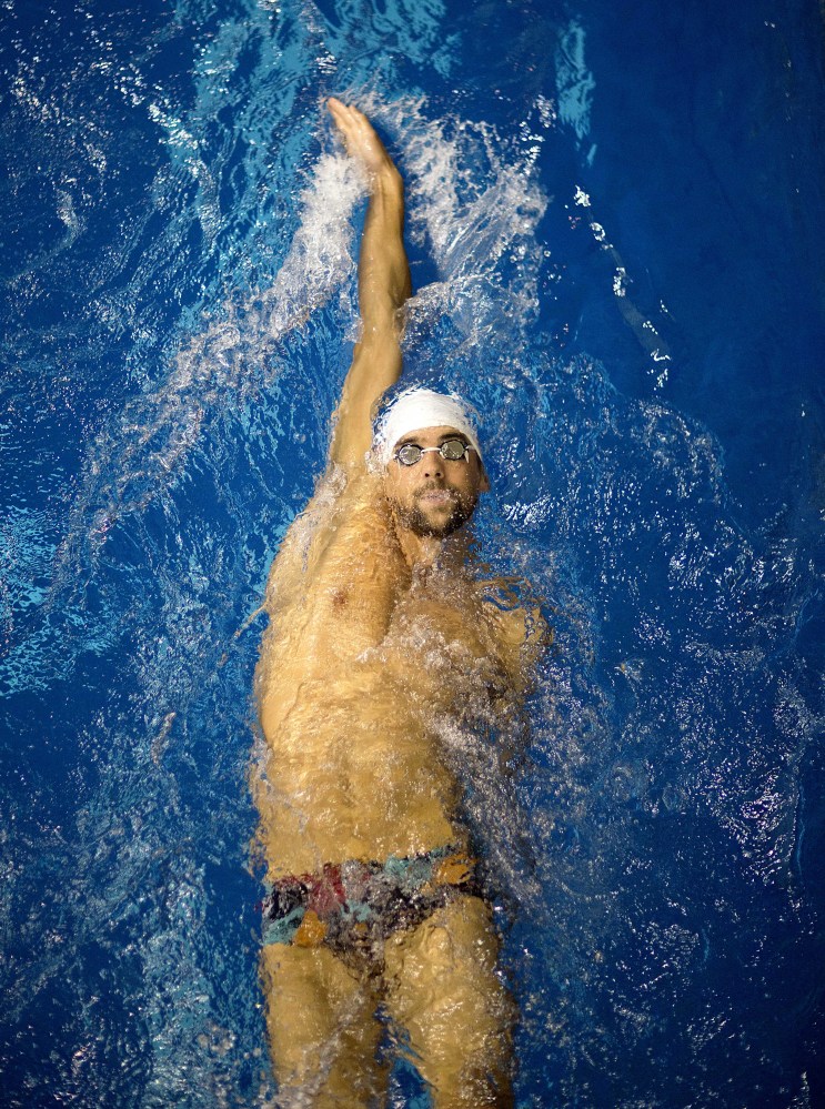 In this July 12, 2014, file photo, Michael Phelps warms up for the men’s 100-meter backstroke at the Bulldog Grand Slam swim meet at the University of Georgia in Athens, Ga.