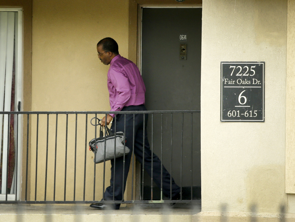 Dr. Christopher Perkins, medical director of the Health Authority with Dallas County Health and Human Services, walks out of an apartment unit at The Ivy Apartment Complex in Dallas on Thursday.