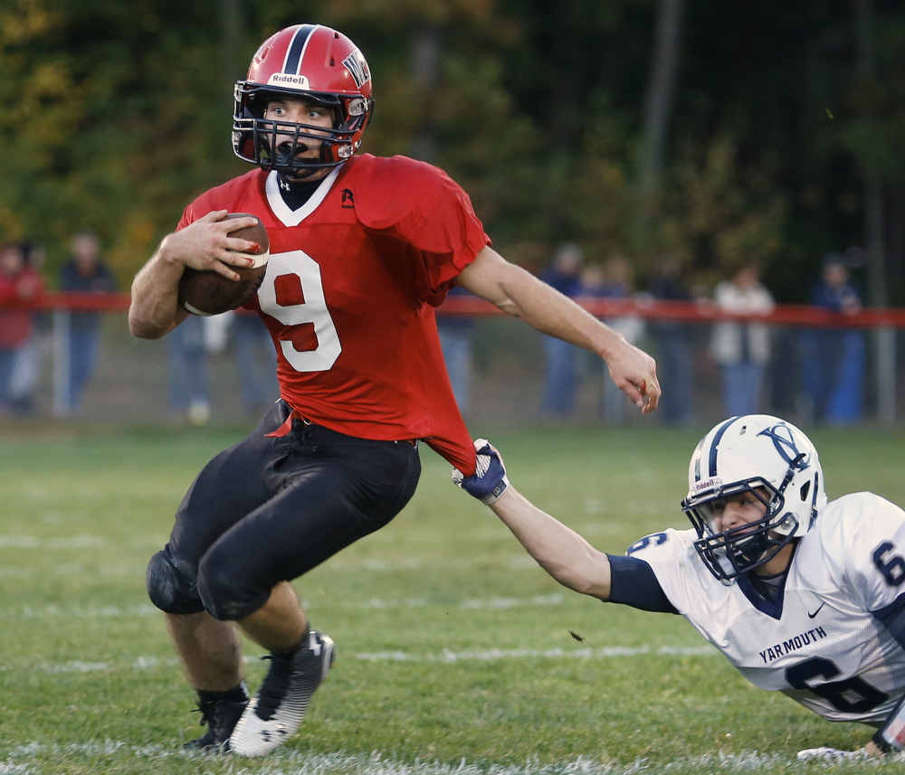 Chris Carney of Wells attempts to break away from Jack Snyder of Yarmouth during the first half of Wells’ 21-14 victory Thursday night. Carney gained 145 yards in the first half and finished with 175, plus a touchdown.