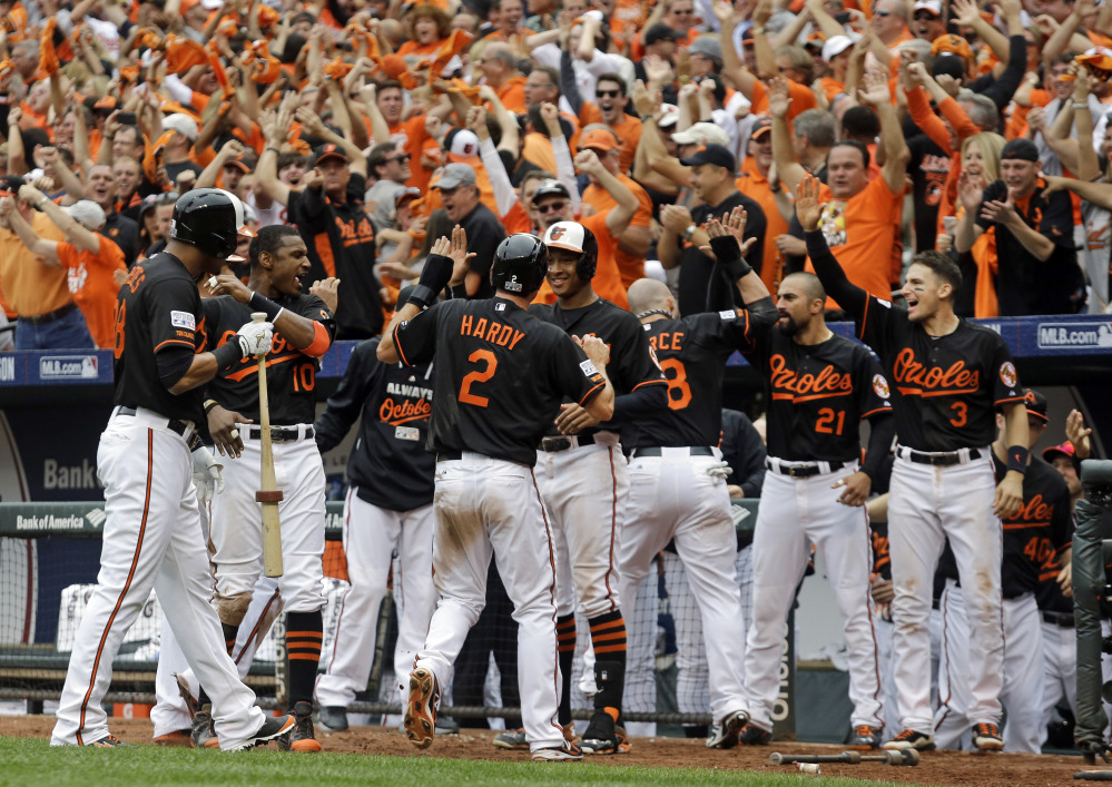 The Baltimore Orioles’ J.J. Hardy (2) celebrates with teammates after scoring the go-ahead run against the Detroit Tigers in the eighth inning of Game 2 of the AL Division Series in Baltimore on Friday.