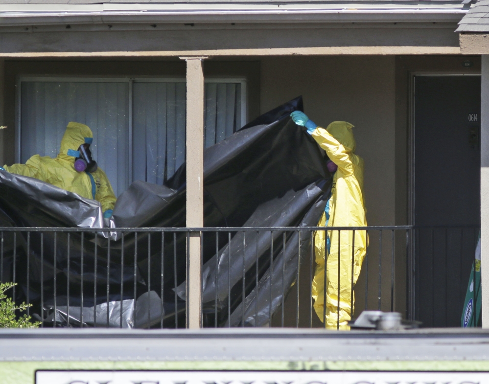 A hazardous-materials crew prepares to hang black plastic Friday outside an apartment in Dallas where an Ebola patient who traveled from Liberia stayed last week.