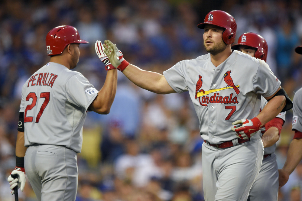 The St. Louis Cardinals’ Matt Holliday is greeted by teammate Jhonny Peralta after hitting a three-run home run against the Los Angeles Dodgers in an eight-run seventh inning of Game 1 of the NL Division Series on Friday in Los Angeles. The Cardinals rallied for a 10-9 victory.