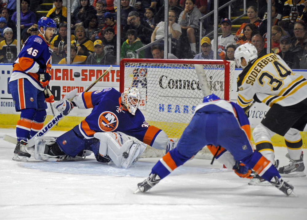 Goalie Chad Johnson of the New York Islanders reaches to make a save on Carl Soderberg of the Boston Bruins during the first period of the Bruins’ 6-1 victory Friday night in an exhibition game at Bridgeport, Conn.