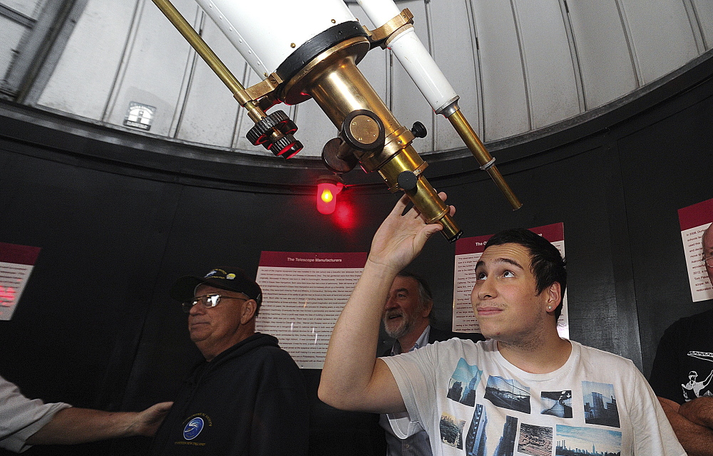 Colton Botelho, a senior at B.M.C. Durfee High School in Fall River, Mass., peers through the eyepiece of the school’s newly restored telescope.