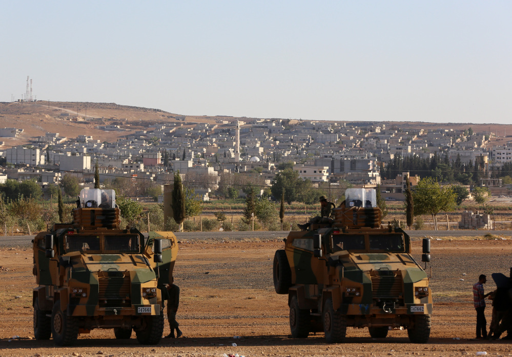 Turkish soldiers take up a defensive position a few hundred meters from their border with Syria as fighting intensified on Saturday between Syrian Kurds and Islamic State forces in nearby Kobani, Syria.
