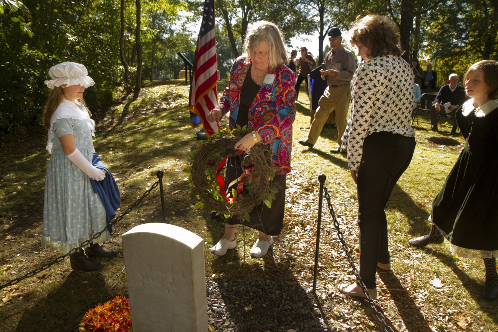 Theresa Sawyer Cobb places a wreath near a memorial stone for the early settlers of East Deering Village being dedicated at Grand Trunk Cemetery in Portland on Sunday. Theresa’s sixth grandfather was Anthony Sawyer, who was one of those settlers and is buried in the cemetery.