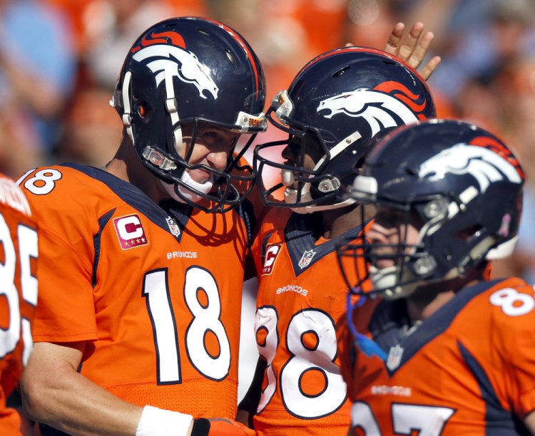 Denver Broncos quarterback Peyton Manning (18) celebrates his touchdown pass to teammate Demaryius Thomas (88) during the first half of an NFL football game against the Arizona Cardinals, Sunday in Denver.