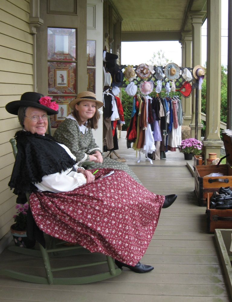 Rita St. Clair, left, and Hayley Rose Hatfield dress in clothes from the Caroline’s Closet room at the  Washburn-Norlands Living History Center in Livermore. Attendees of the center’s fall festival are invited to try on some fashions of yesteryear during Saturday’s festivities.