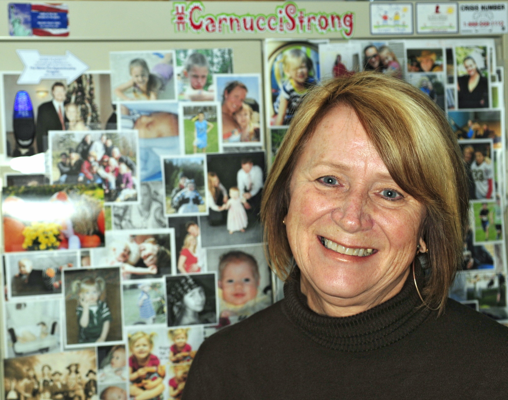 Charle Clark displays a Carnucci Strong sign with family photos in her office at the Winthrop police station. 