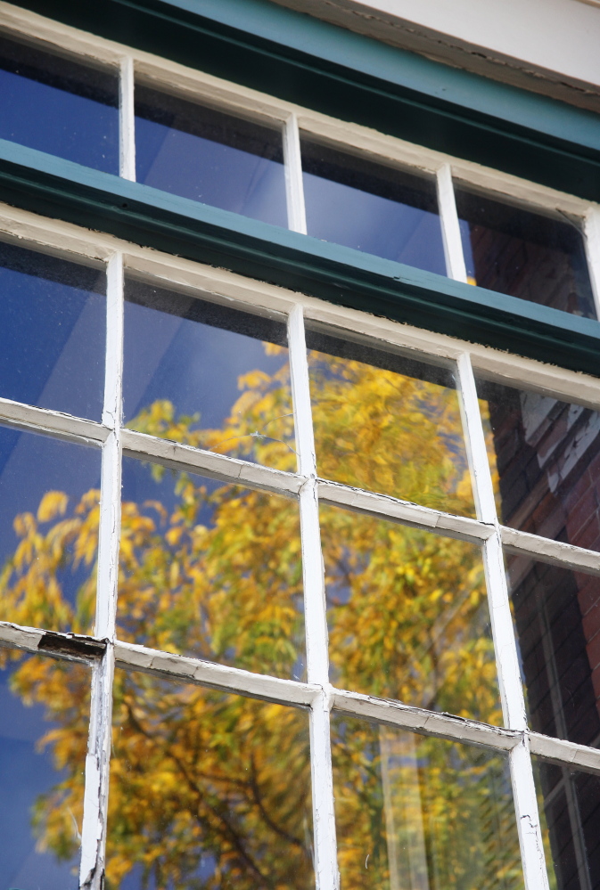 Antique windows reflect foliage at 147 Congress St. Jill Brady/Staff Photographer