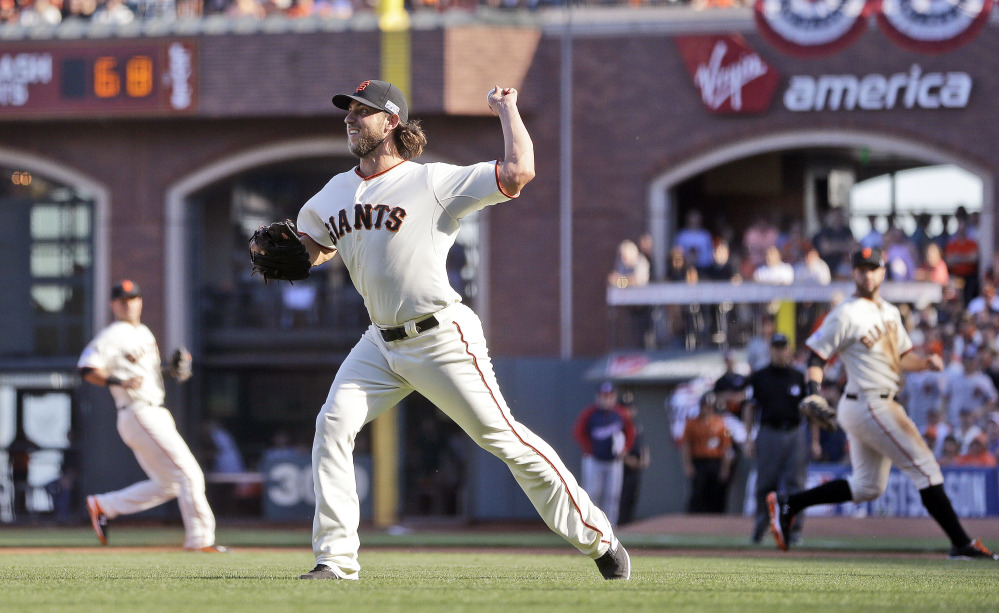 Giants pitcher Madison Bumgarner makes a throw to third for an error that allowed two runs in the seventh inning against the Washington Nationals in Game 3 of the NL Division Series in San Francisco on Monday.