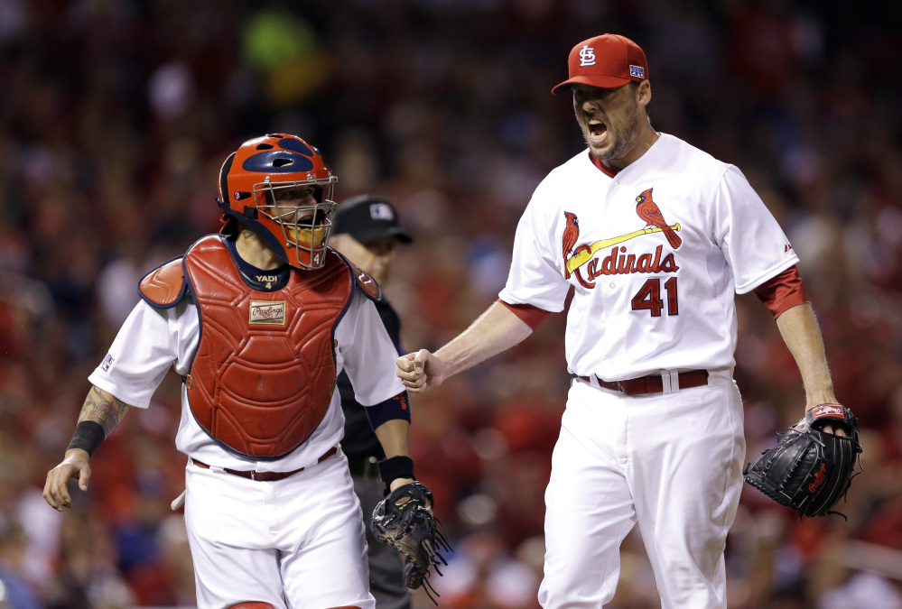 St. Louis Cardinals pitcher John Lackey reacts with catcher Yadier Molina after throwing out the Los Angeles Dodgers’ Carl Crawford at first base in the fourth inning of Game 3 of the NL Division Series on Monday in St. Louis.