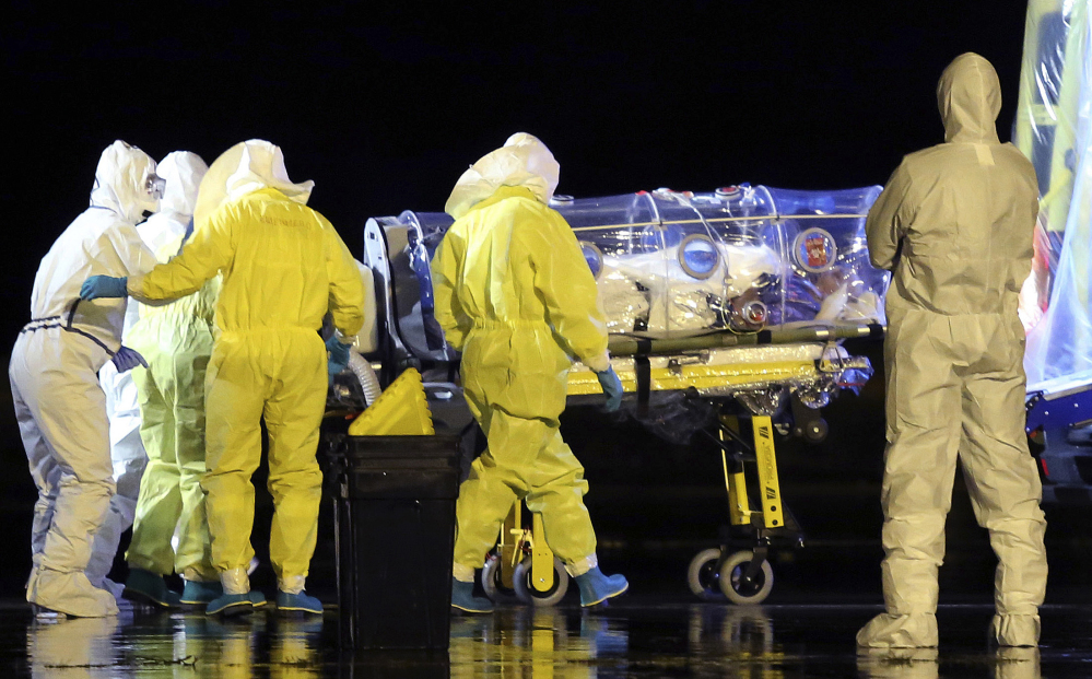 Aid workers and doctors transfer Manuel Garcia Viejo, a Spanish priest who was diagnosed with the Ebola virus while working in Sierra Leone, from a military plane to an ambulance as he leaves the Torrejon de Ardoz military airbase, near Madrid, Spain.