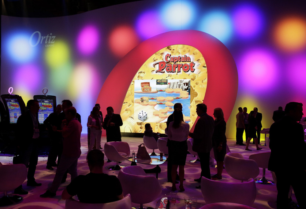 People visit the Ortiz Gaming booth during the Global Gaming Expo in Las Vegas this month. Slot machine manufacturers are updating games with more current themes and features such as touch screens to attract younger dollars.