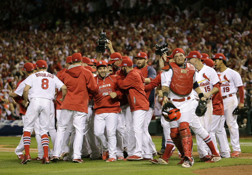 St. Louis Cardinals players celebrate their 3-2 win Tuesday over the Los Angeles Dodgers in Game 4 of the NL Division Series in St. Louis. The Cardinals won the best-of-five series in four games.