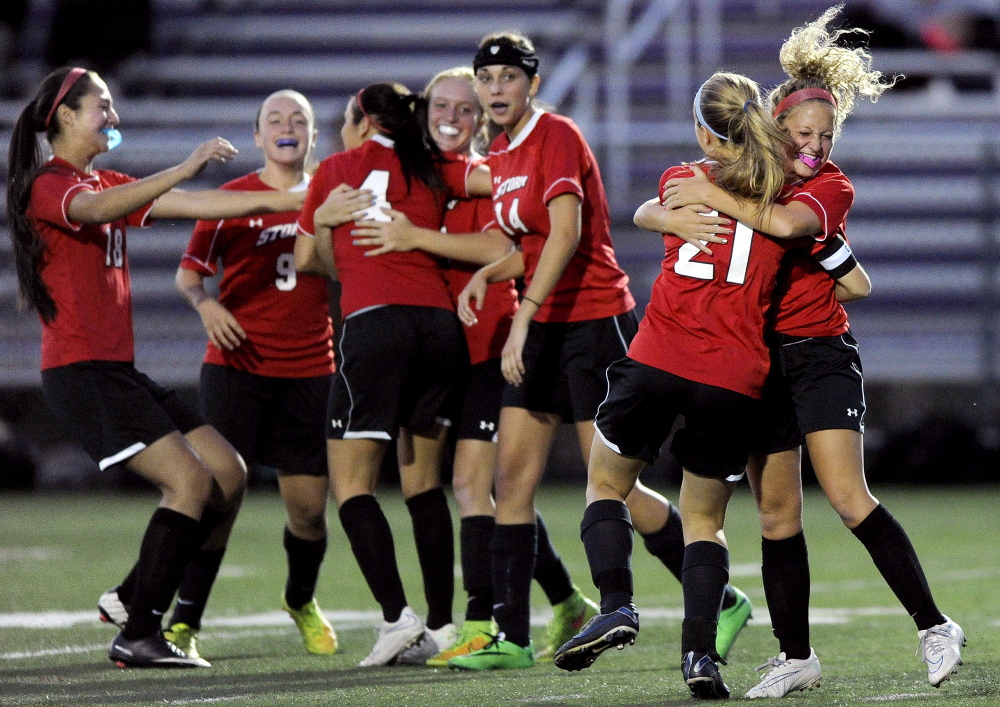Katherine Kirk, 21, receives a hug from Scarborough teammate Maddie Chen after Kirk fed a pass to Ashley Gleason for a goal early in the second half Wednesday night in Portland. Scarborough won, 2-0.