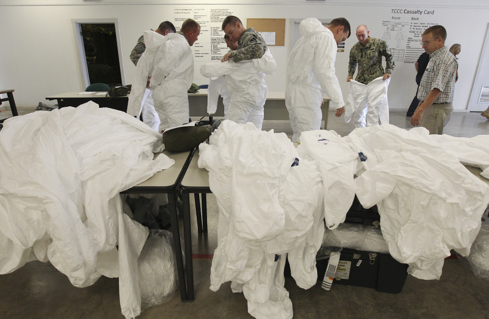 Soldiers from the 36th Engineer Brigade try on protective clothing for sizing during a training session at Fort Hood, Texas, on Thursday. The 450 soldiers from the brigade will be among the first to be deployed from Fort Hood to Liberia.