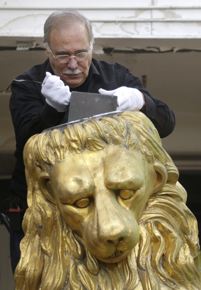 Sculptor and art restorer Robert Shure, on Thursday in Woburn, Mass., removes the copper box from a lion statue that usually ornaments Boston’s Old State House.