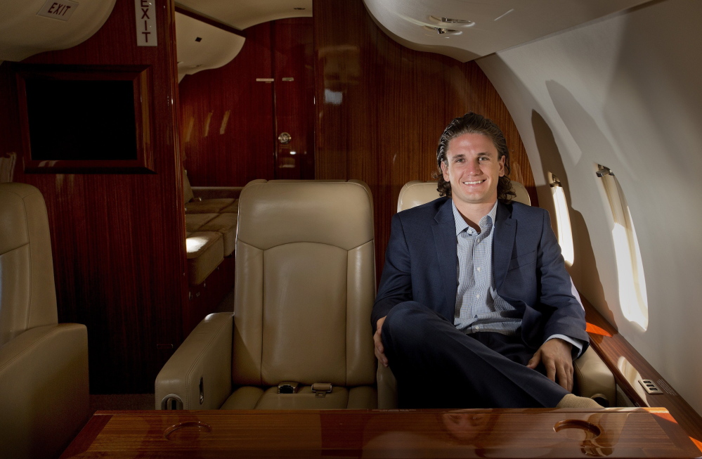 Portland native Johnny Sengelmann sits on a private plane owned by charter company Maine Aviation Corp. at the Portland International Jetport. Maine Aviation is offering discount private flights through Fresh Jets, a service co-founded by Sengelmann that links the public with open seats on charter planes.