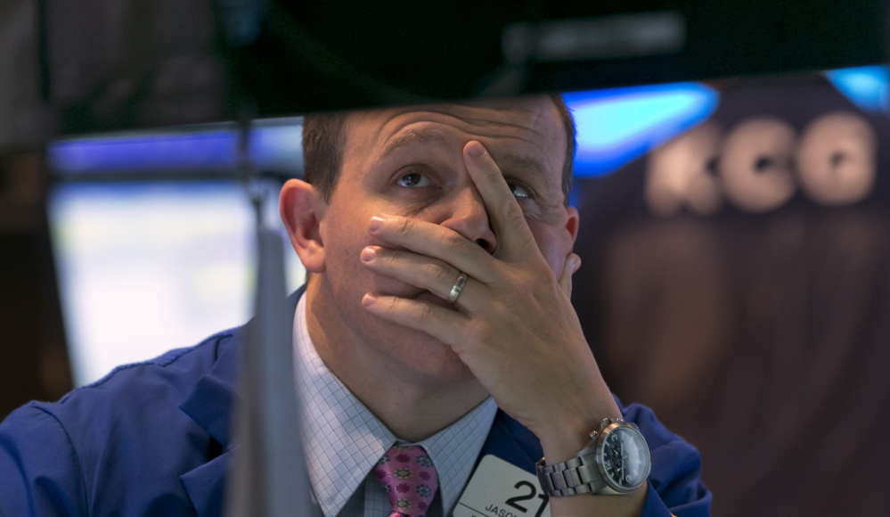 Specialist Jason Notter works at his post on the floor of the New York Stock Exchange near the close of trading Friday. U.S. stocks closed out with another loss, with technology shares especially hard-hit.
