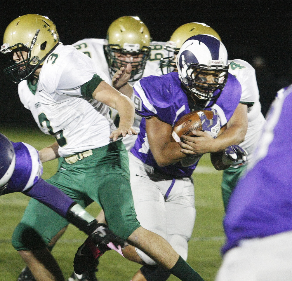 Kahlil Brown of Deering is grabbed by Jon Blake of Oxford Hills while attempting to gain yardage in their Eastern Class A game Friday night. Oxford Hills earned a 21-9 victory.