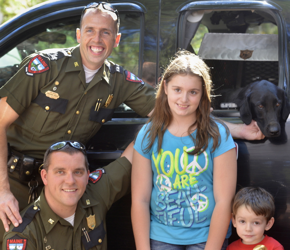 Wardens Jonathan Parker and Alan Curtis and their faithful dog, Sig, pose with fans Kaitlyn Clark, 11, and her 3-year-old brother, Dylan, from Lyman.