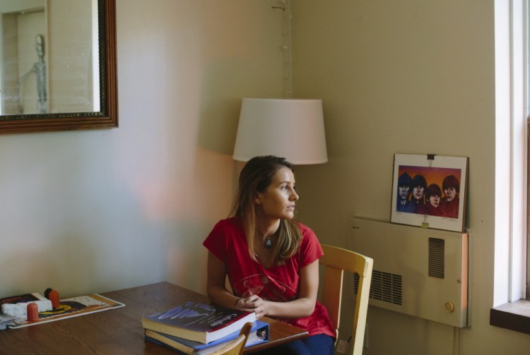 University of Maine sophomore Olivia Conrad sits in her Orono apartment  last week. Conrad transferred from St. Lawrence University, a private school, after a freshman year that left her $25,000 in debt. “I’m always thinking about a job. Thinking about paying off that debt,” she said.