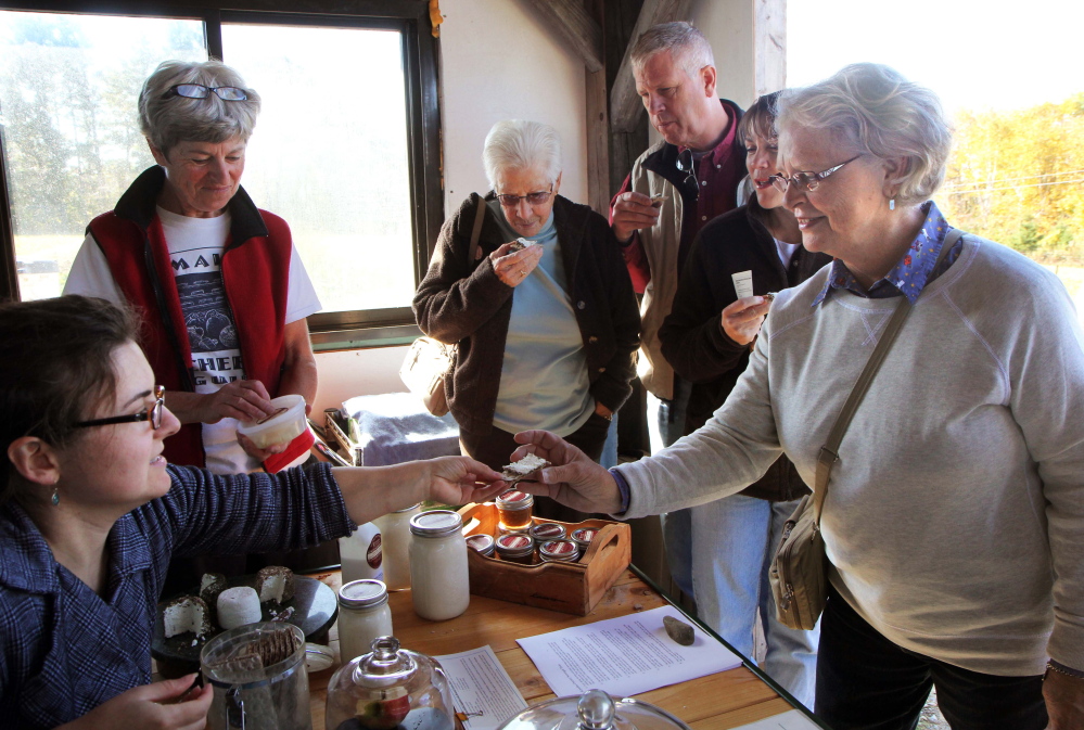 Sylvie Boisvert, left, hands Trudy Ellis of Chelsea a sample of goat cheese at Kennebec Cheesery at Koons Farm in Sidney on Sunday during Maine Open Creamery Day.