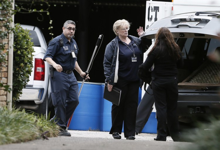 Animal service Officer Luis Gomez, left, Senior program manager for Code Compliance Jody Jones, center, and and unidentified woman, right, on hand to remove a dog at a healthcare workers apartment, who tested positive for Ebola, in Dallas. (AP Photo/Brandon Wade)