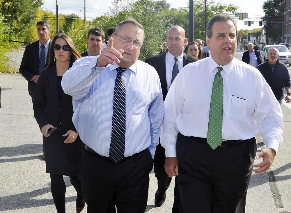 New Jersey Gov. Chris Christie, right, listens as he walks with Maine Gov. Paul LePage in Lewiston’s “Little Canada” neighborhood, where LePage grew up.
