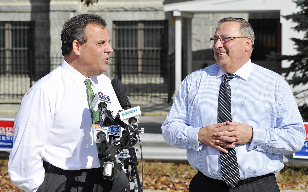 New Jersey Gov. Chris Christie answers questions from the media while standing with Maine Gov. Paul LePage in the area of Lewiston where LePage grew up. Christie, chairman of the Republican Governors Association, touted LePage’s efforts to increase private sector jobs in Maine.