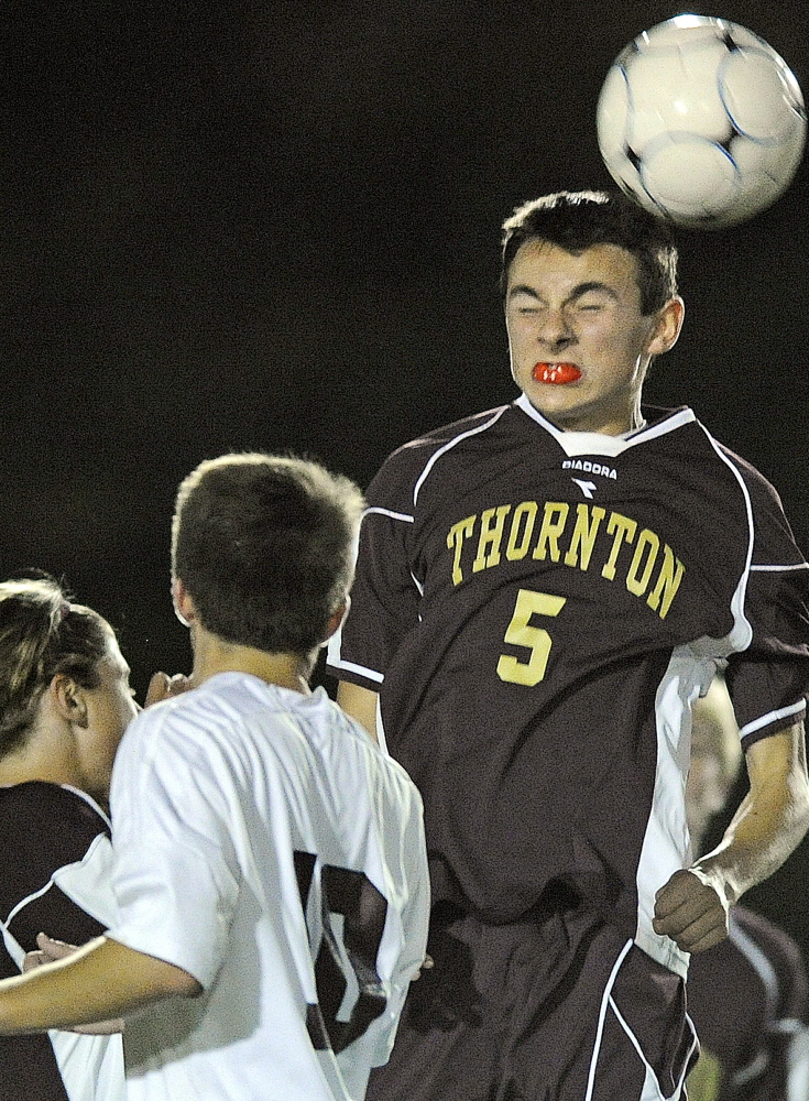 Alex Arnold of Thornton Academy gets his head on the ball in front of Cody Elliott, 10, of Gorham during their SMAA boys’ soccer game Tuesday night at Gorham. The game ended in a 1-1 tie.
