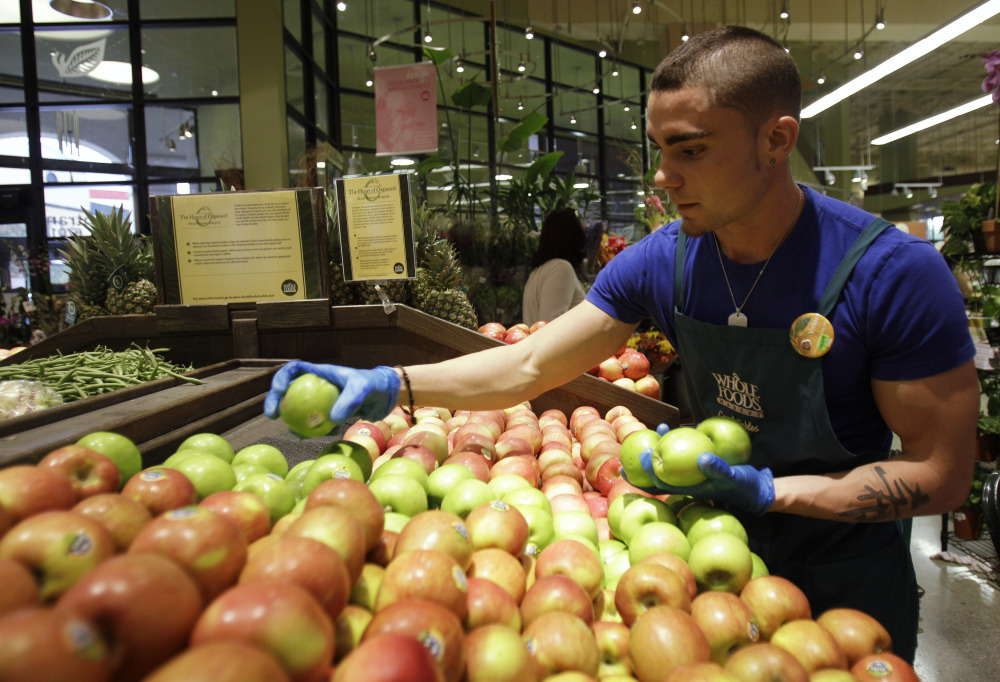 Victor Hernandez stocks apples in the produce section at Whole Foods, in Coral Gables, Fla., in 2010.