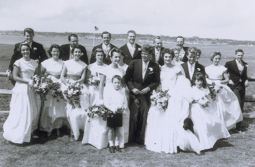 In this Sept. 12, 1953, photo released by RR Auction, John F. Kennedy and his new bride, Jacqueline, front right, pose with members of the wedding party in Newport, R.I. The photo is one of a collection of 13 original images made by Frank Ataman of Fall River, Mass., that were auctioned by RR Auction. The original negatives were discovered in his darkroom after he died.