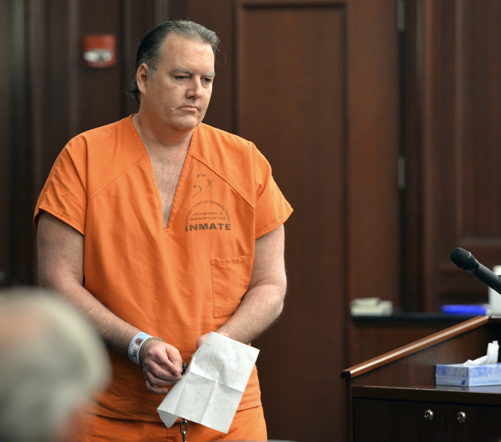 Michael Dunn returns to his seat after reading his statement, which included an apology to the victim’s family, during his sentencing Friday in Jacksonville, Fla.