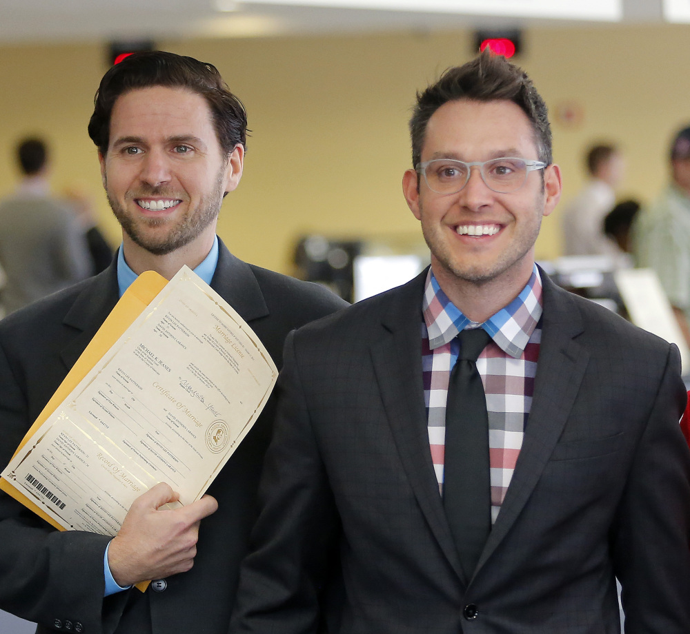 Kevin Patterson, left, and David Larance show their Arizona marriage license Friday in Phoenix. Gay marriage became legal after a federal court decision cleared the way for same-sex unions.
