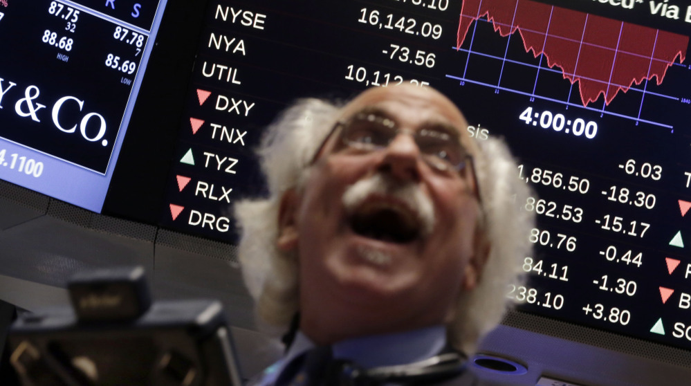 Trader Peter Tuchman watches a screen above the floor of the New York Stock Exchange on Wednesday, as the Dow plummeted as much as 460 points, then regained much of the ground it lost.